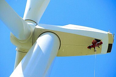 Höhenrettung aus der Krankluke einer windenergieanlage mit einer Rettungskraft und einem verletzen Servicemitarbeitenden, der liegend in der Trage abgeseilt wird.