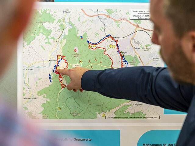 Projektleiter zeigt Standorte von geplanten Windräder auf einer Standortkarte.