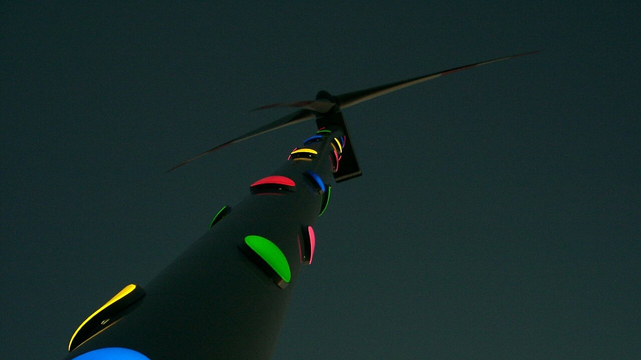 30 leuchtende Farbfelder sorgen dafür, dass das Kunstwerk auch im Dunkeln seine Wirkung entfaltet. Die Windenergieanlage im Dunkeln. Die bunten Punkte leuchten.